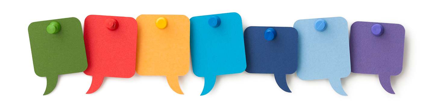Seven blank colourful speech bubbles pinned to a white surface.