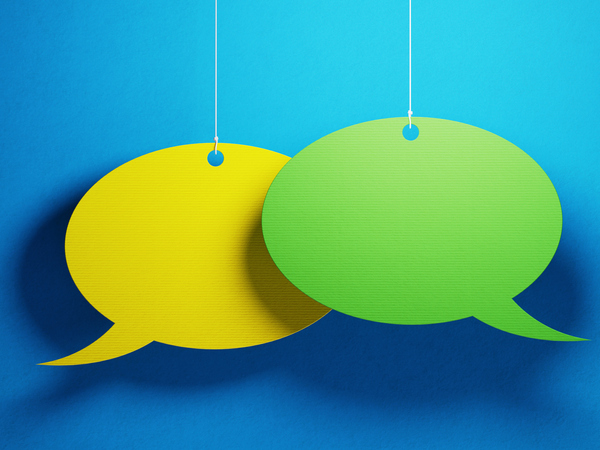 Yellow and green coloured chat bubbles over blue background.
